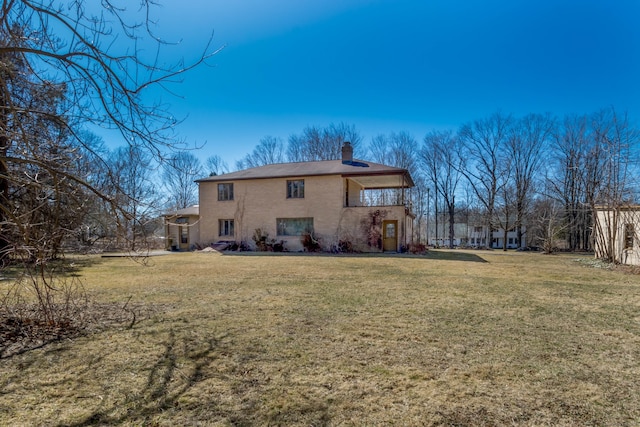 back of property featuring a lawn and a chimney