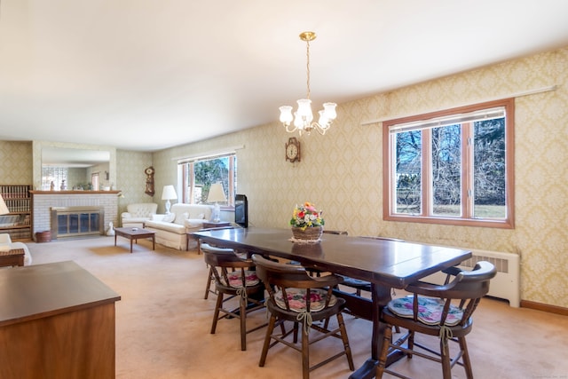 dining area with light carpet, radiator, wallpapered walls, and a fireplace