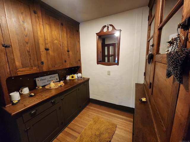 interior space with light wood-type flooring, baseboards, and dark countertops