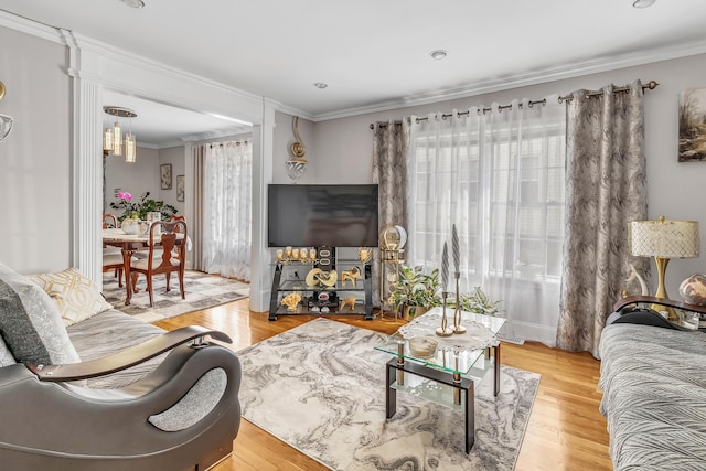 living room with light wood-style flooring and ornamental molding