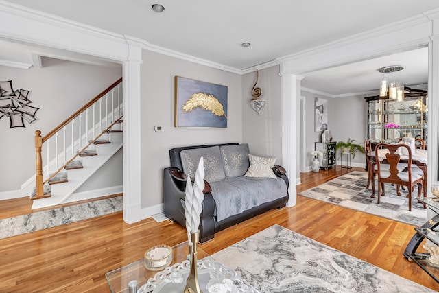 living area with stairway, baseboards, wood finished floors, and crown molding