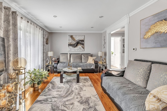 living area with ornamental molding and wood finished floors