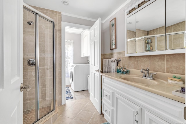 full bath featuring tile patterned floors, washing machine and dryer, a stall shower, and vanity