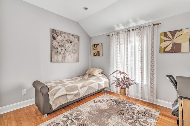 bedroom featuring vaulted ceiling, wood finished floors, and baseboards