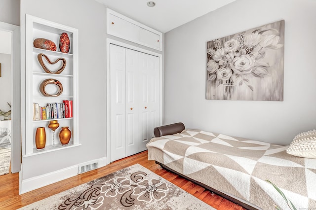 bedroom featuring a closet, visible vents, and wood finished floors