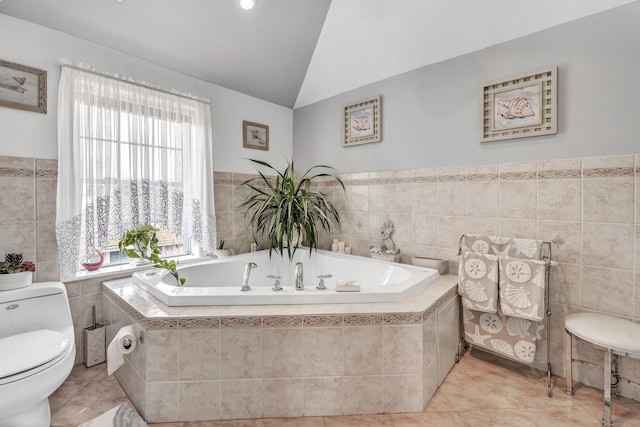 bathroom featuring tile patterned flooring, toilet, a garden tub, lofted ceiling, and tile walls