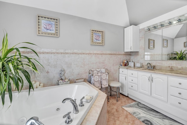 full bath with vanity, a whirlpool tub, vaulted ceiling, tile patterned floors, and tile walls