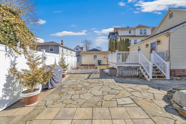 view of patio / terrace featuring a wooden deck, a residential view, a grill, and fence private yard