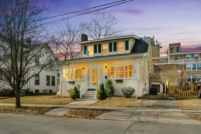 bungalow-style home featuring an outbuilding, fence, driveway, and a chimney