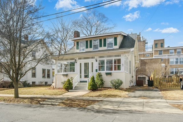 bungalow-style home with an outbuilding, roof with shingles, driveway, a chimney, and entry steps