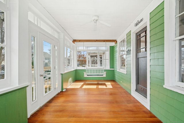 unfurnished sunroom featuring ceiling fan