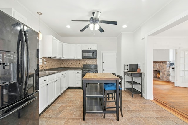 kitchen featuring backsplash, black appliances, crown molding, and a sink