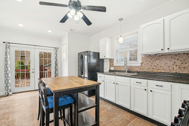 kitchen featuring a sink, dark countertops, french doors, crown molding, and decorative backsplash