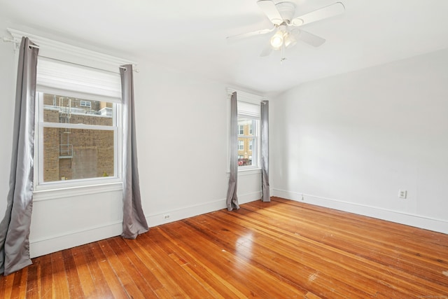 empty room with baseboards, hardwood / wood-style floors, and a ceiling fan