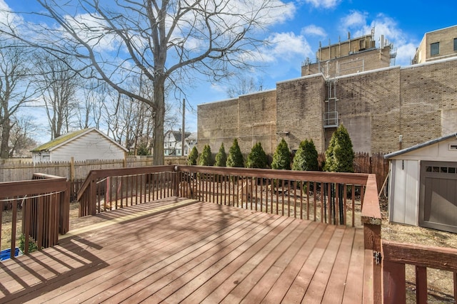 wooden terrace with an outbuilding and a fenced backyard