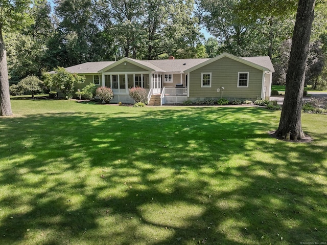 rear view of house with a porch and a yard