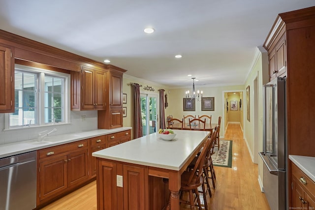 kitchen with a sink, a kitchen breakfast bar, a kitchen island, stainless steel appliances, and a chandelier