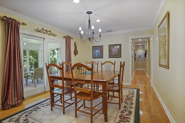 dining space featuring visible vents, baseboards, light wood-type flooring, ornamental molding, and a notable chandelier