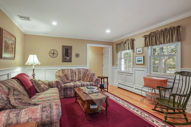 living room featuring wainscoting, wood finished floors, visible vents, and ornamental molding