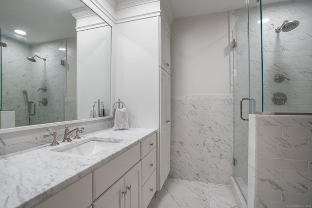 bathroom featuring tile walls, marble finish floor, a stall shower, and vanity