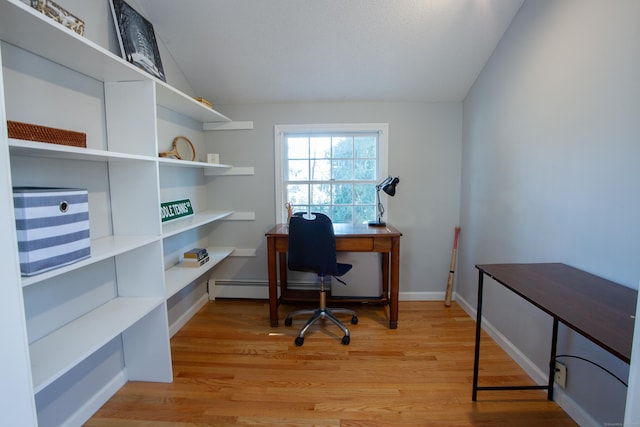 office area with light wood-type flooring, baseboards, and vaulted ceiling