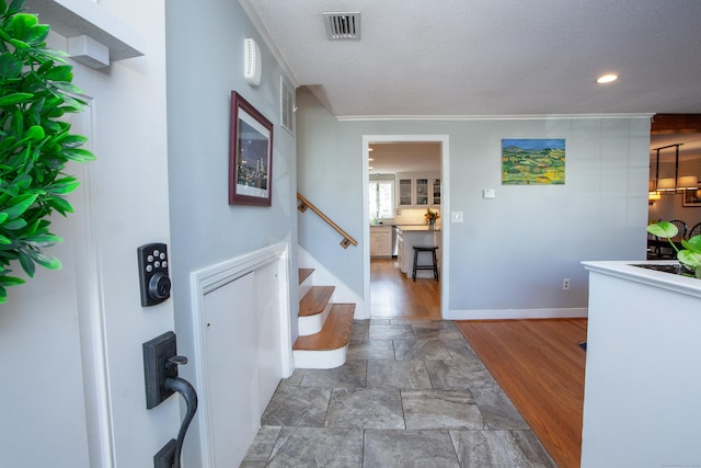 interior space with visible vents, baseboards, stairs, wood finished floors, and a textured ceiling