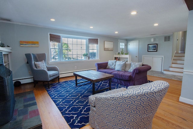 living area with a baseboard radiator, visible vents, and a fireplace