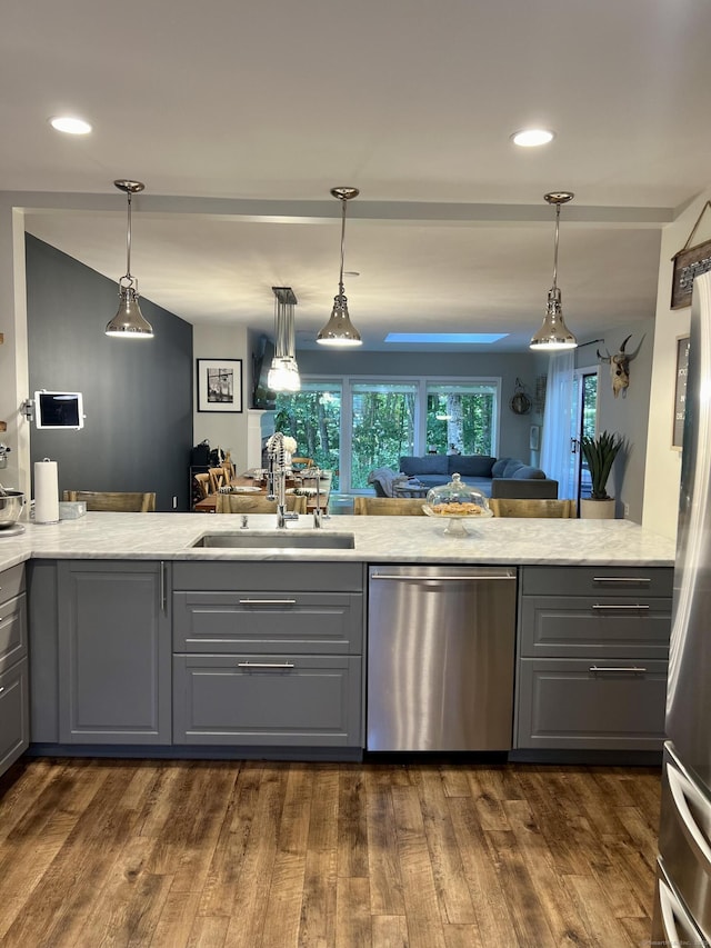 kitchen with a sink, dark wood-type flooring, appliances with stainless steel finishes, and gray cabinetry