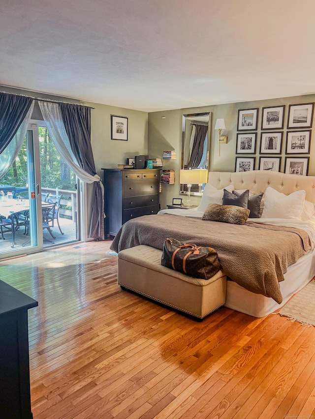 bedroom with access to exterior and hardwood / wood-style flooring