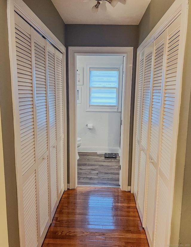 hallway with baseboards and wood finished floors