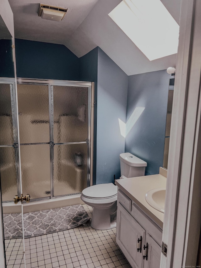 bathroom featuring vaulted ceiling with skylight, toilet, a stall shower, and vanity