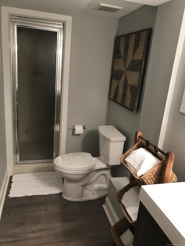 full bath featuring visible vents, a shower stall, toilet, and wood finished floors