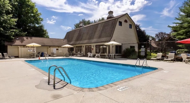 community pool featuring a patio area and fence