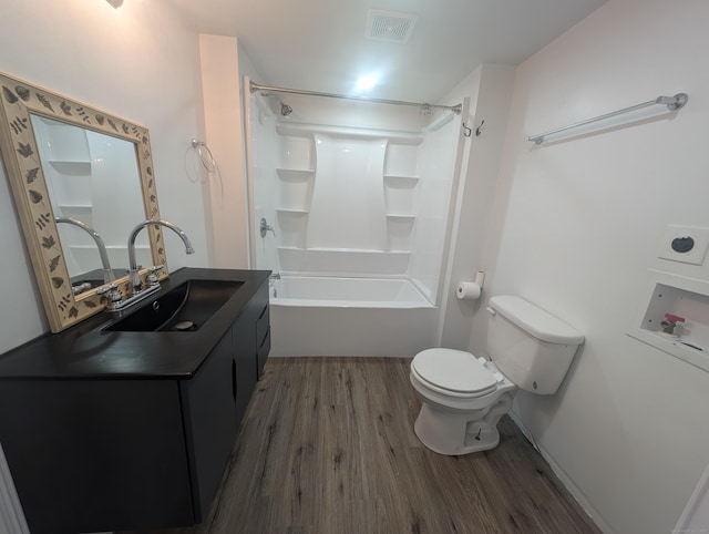 bathroom with visible vents, toilet, vanity, wood finished floors, and washtub / shower combination