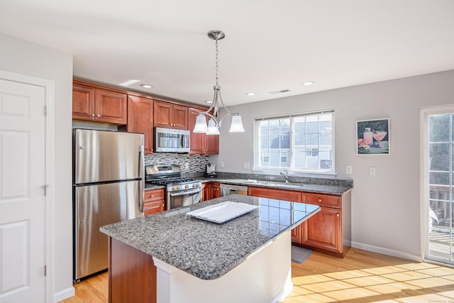 kitchen featuring visible vents, light wood-style flooring, a sink, appliances with stainless steel finishes, and tasteful backsplash