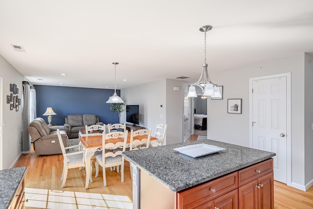 kitchen featuring pendant lighting, light wood-type flooring, visible vents, and open floor plan