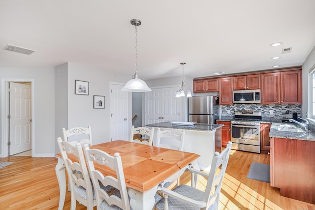 dining area featuring light wood-style flooring, recessed lighting, visible vents, and baseboards