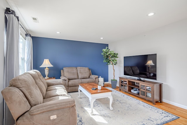 living area featuring recessed lighting, light wood-style flooring, visible vents, and baseboards