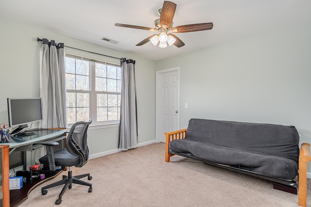 home office with visible vents, light colored carpet, baseboards, and a ceiling fan