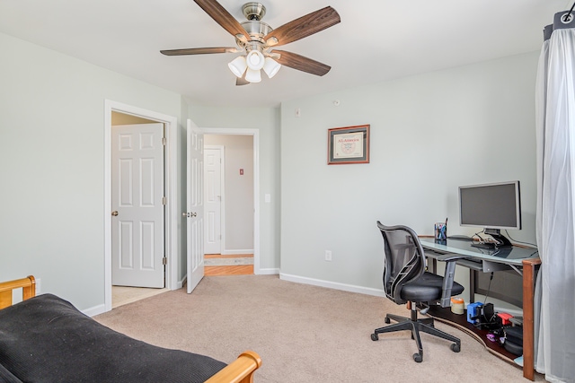 carpeted home office with baseboards and ceiling fan