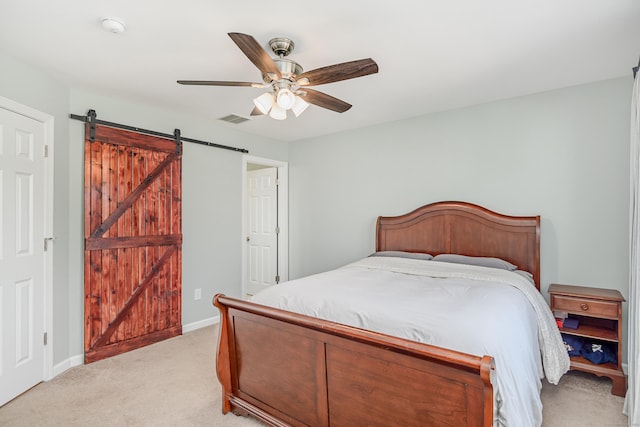 bedroom featuring visible vents, light carpet, a barn door, baseboards, and ceiling fan