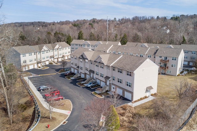 drone / aerial view with a residential view and a wooded view