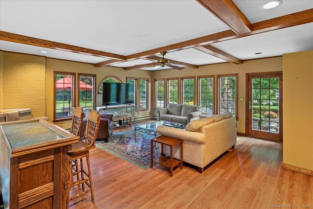 living room featuring beamed ceiling, light wood-style flooring, a ceiling fan, and baseboards