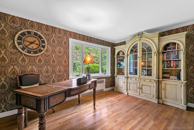 office with wallpapered walls, radiator, and light wood-type flooring