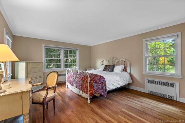 bedroom featuring radiator, wood finished floors, and crown molding