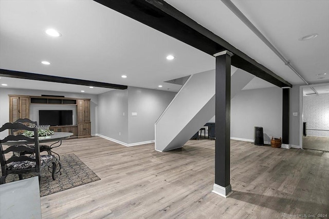 finished below grade area with recessed lighting, stairway, baseboards, and wood finished floors