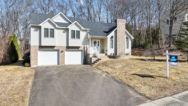 split level home with brick siding, a shingled roof, aphalt driveway, a chimney, and an attached garage