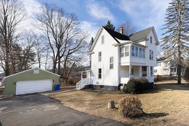 view of side of home featuring a detached garage, an outbuilding, a chimney, and a shingled roof