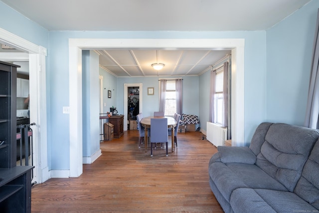 dining area featuring radiator heating unit, wood finished floors, baseboards, and coffered ceiling