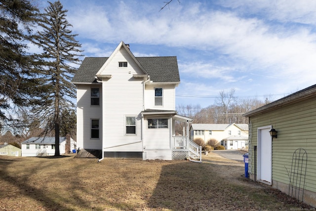 rear view of house with roof with shingles